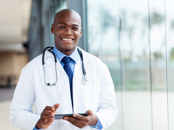 Physician smiles as he hold a tablet in his hands